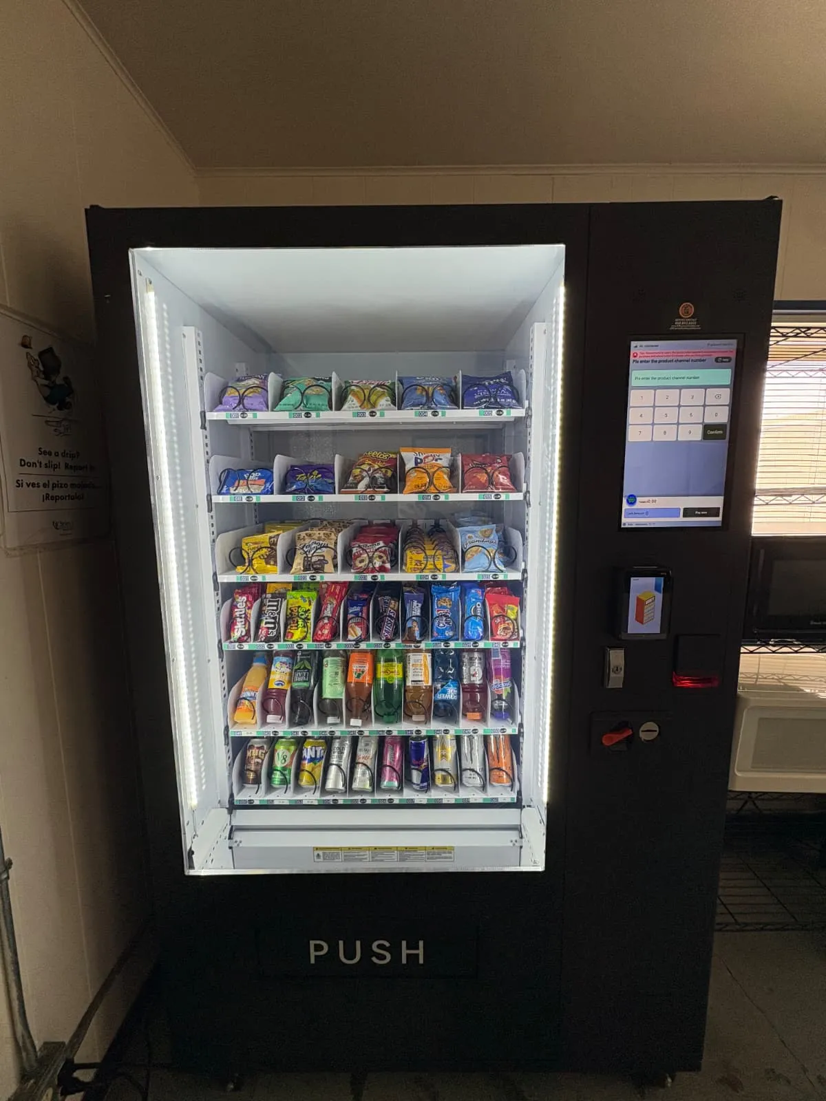 Modern touchscreen combo vending machine stocked with snacks and cold drinks, accepting cash and tap-to-pay